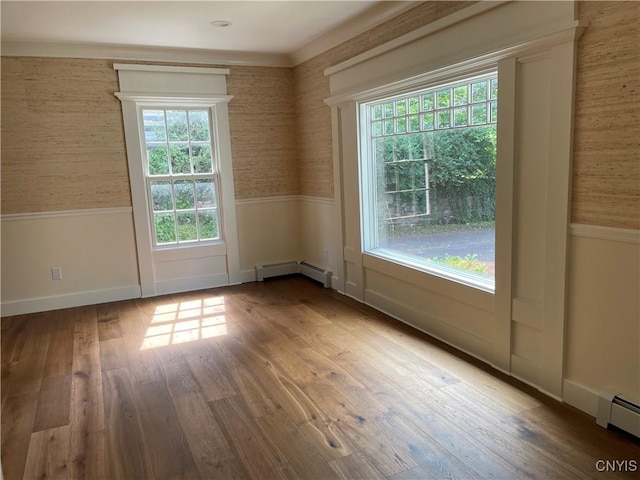 203 E Genesee St, Manlius, NY 13066 - spare room with baseboard heating, wainscoting, wallpapered walls, and wood finished floors