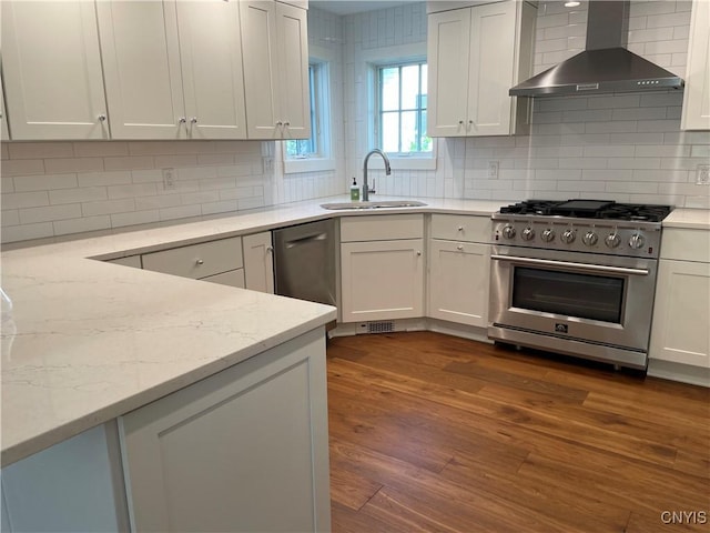 203 E Genesee St, Manlius, NY 13066 - kitchen featuring stainless steel appliances, wall chimney exhaust hood, dark wood-style flooring, decorative backsplash, and light stone countertops
