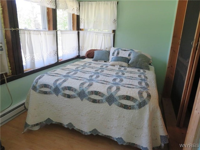 8211 Elmwood Dr, Rushford, NY 14717 - bedroom with wood finished floors and a baseboard radiator