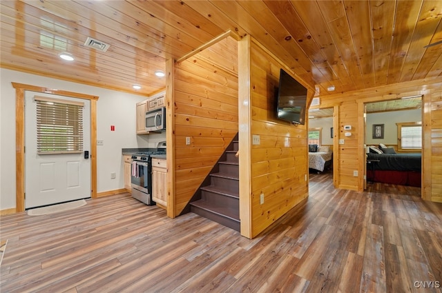 224 Macarthur Rd, Russia, NY 13324 - kitchen featuring appliances with stainless steel finishes, light wood-type flooring, wooden ceiling, wooden walls, and dark countertops