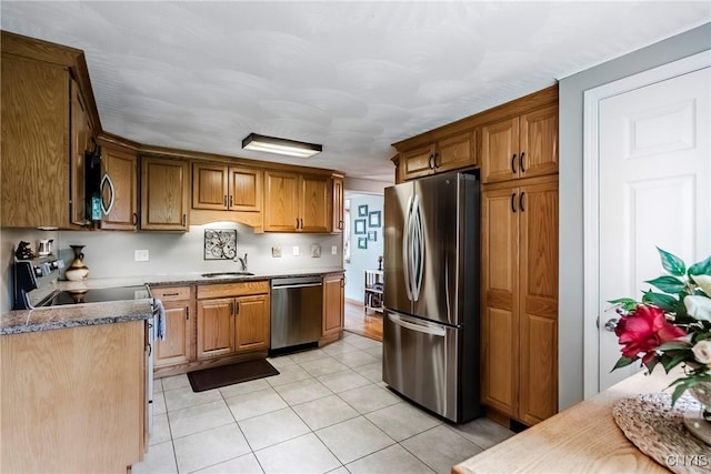 6954 Rome Oriskany Rd, Rome, NY 13440 - kitchen with stainless steel appliances, light tile patterned floors, and brown cabinets