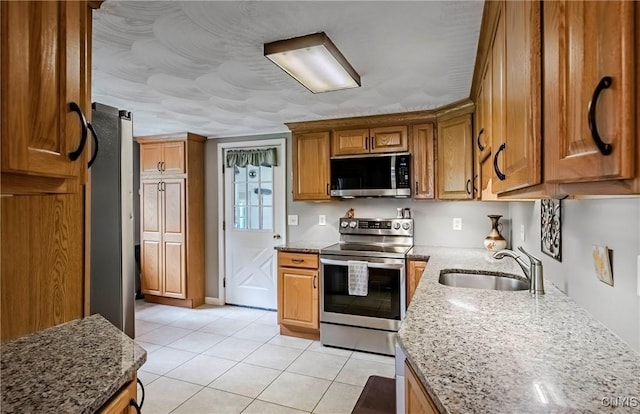 6954 Rome Oriskany Rd, Rome, NY 13440 - kitchen featuring appliances with stainless steel finishes, light tile patterned floors, light stone countertops, and brown cabinets
