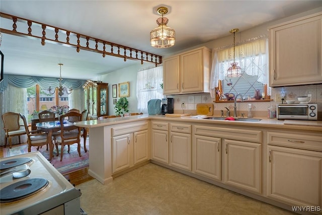 174 Homewood Ave, Tonawanda, NY 14217 - kitchen featuring a chandelier, light countertops, backsplash, and pendant lighting
