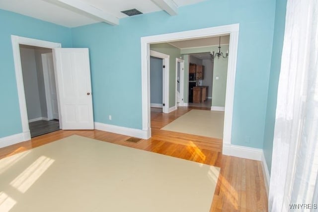 45 S Academy St, Middlebury, NY 14591 - unfurnished bedroom with a chandelier, beam ceiling, and wood finished floors
