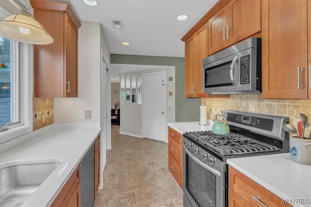 34 Northfield Pl, Amherst, NY 14226 - kitchen featuring stainless steel appliances, light countertops, plenty of natural light, brown cabinets, and recessed lighting