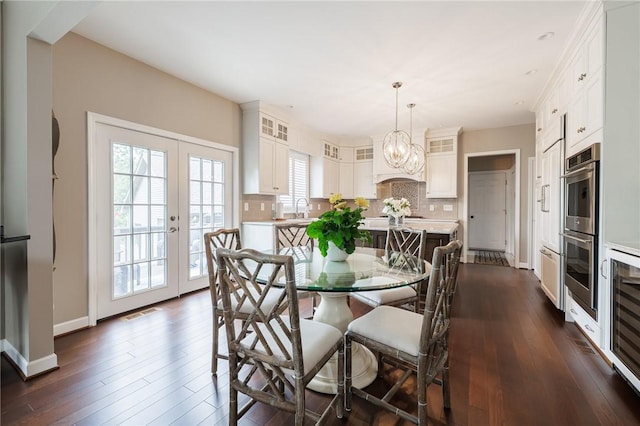 31 Spruce Rdg, Perinton, NY 14450 - dining space featuring dark wood finished floors, a chandelier, french doors, and beverage cooler