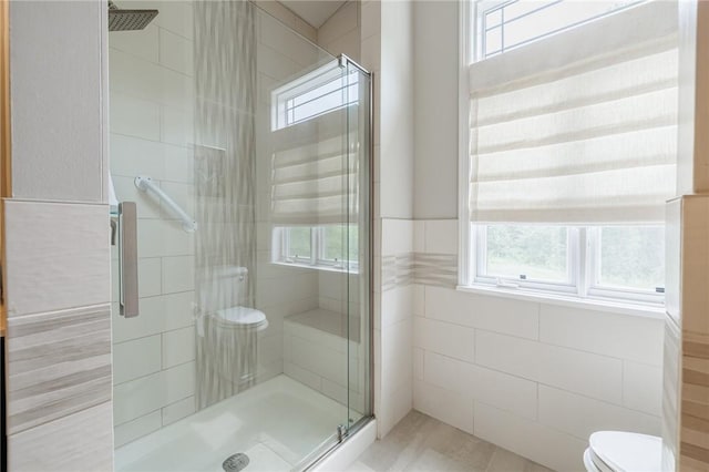 31 Spruce Rdg, Perinton, NY 14450 - bathroom with healthy amount of natural light, a stall shower, and tile walls