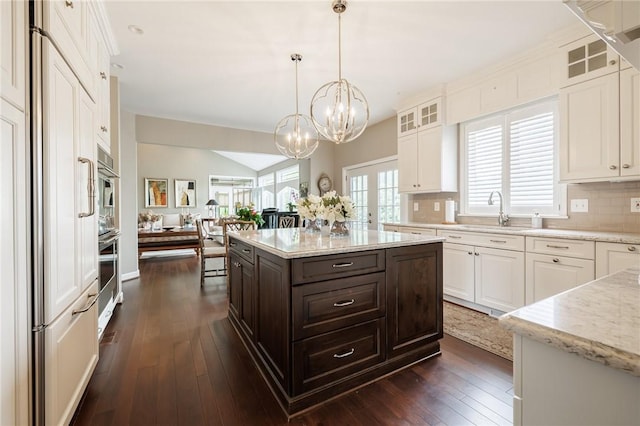 31 Spruce Rdg, Perinton, NY 14450 - kitchen featuring white cabinets, dark brown cabinetry, a chandelier, paneled fridge, and glass insert cabinets