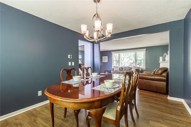 218 Fox Hall Dr, Irondequoit, NY 14609 - dining space featuring a chandelier, a textured ceiling, and wood finished floors