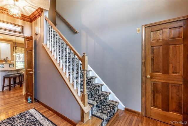 5477 Pebble Beach Dr, Hamburg, NY 14075 - staircase featuring a chandelier and wood finished floors