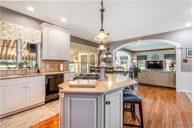 5477 Pebble Beach Dr, Hamburg, NY 14075 - kitchen with arched walkways, dishwasher, stainless steel gas stovetop, light wood-style floors, and wainscoting