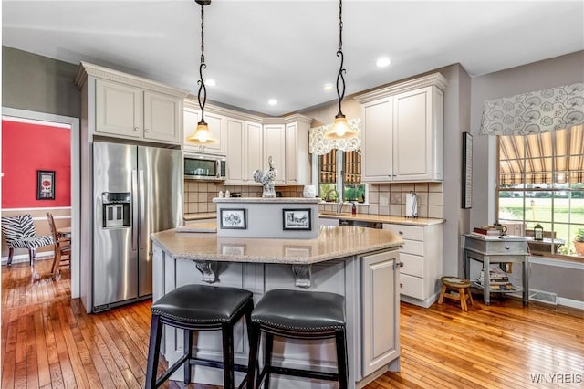 5477 Pebble Beach Dr, Hamburg, NY 14075 - kitchen featuring stainless steel appliances, a kitchen island, light wood-style flooring, plenty of natural light, and recessed lighting
