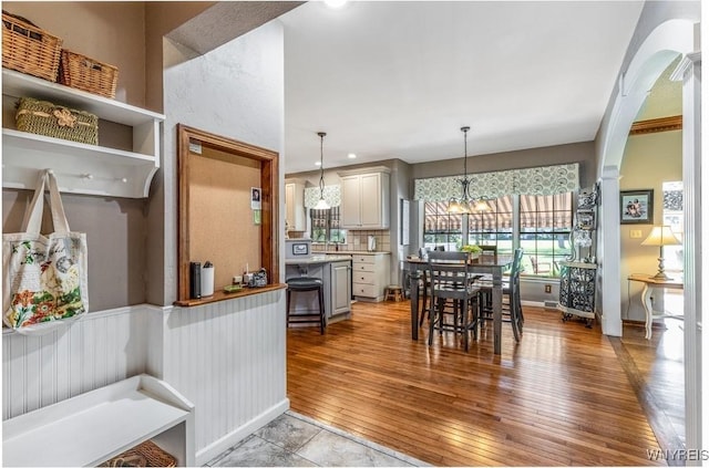 5477 Pebble Beach Dr, Hamburg, NY 14075 - kitchen with light wood-style floors, decorative light fixtures, light countertops, arched walkways, and a chandelier