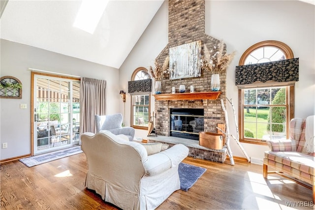 5477 Pebble Beach Dr, Hamburg, NY 14075 - living room with high vaulted ceiling, wood finished floors, a fireplace, and a skylight