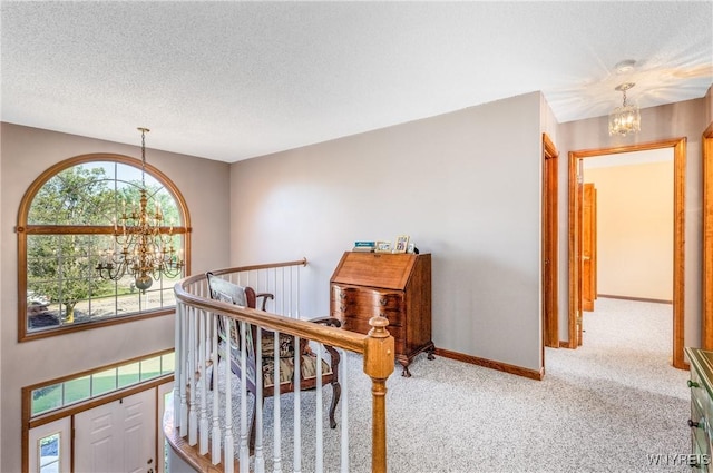 5477 Pebble Beach Dr, Hamburg, NY 14075 - corridor with a chandelier, plenty of natural light, carpet flooring, an upstairs landing, and a textured ceiling