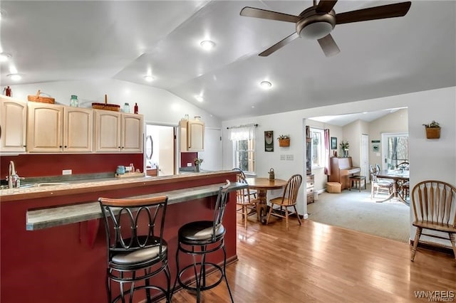 8515 Rte 243, Rushford, NY 14777 - kitchen with a kitchen bar, lofted ceiling, light brown cabinetry, a ceiling fan, and light wood-style flooring
