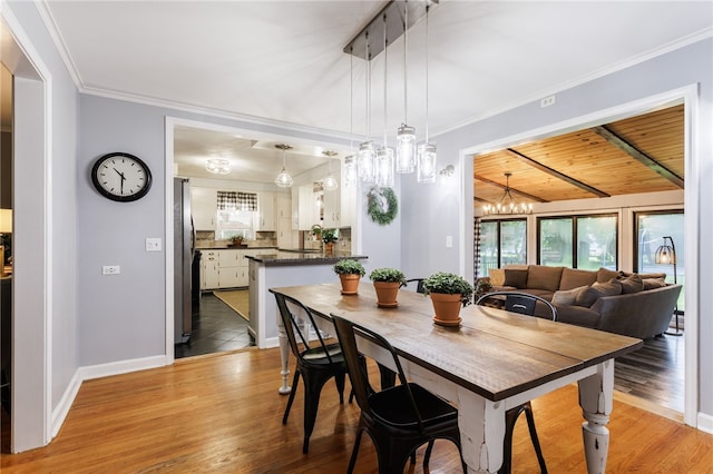 80 Rock Beach Rd, Irondequoit, NY 14617 - dining area with plenty of natural light, a chandelier, light wood finished floors, ornamental molding, and wooden ceiling