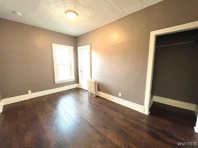 29 Avery Ave, Buffalo, NY 14216 - unfurnished bedroom with radiator, dark wood-type flooring, and a textured ceiling