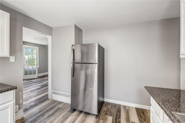 717 Lasalle Ave, Buffalo, NY 14215 - kitchen with freestanding refrigerator, wood finished floors, white cabinetry, and dark stone countertops