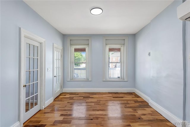 152 Mulberry St, Buffalo, NY 14204 - empty room with a wall unit AC and wood finished floors