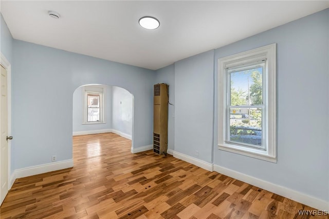 152 Mulberry St, Buffalo, NY 14204 - empty room with arched walkways, a smoke detector, and light wood-style flooring