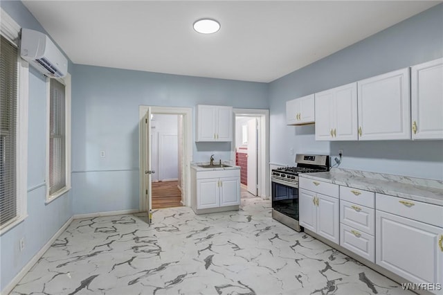152 Mulberry St, Buffalo, NY 14204 - kitchen with gas stove, a wall mounted AC, light countertops, light marble finish flooring, and white cabinets