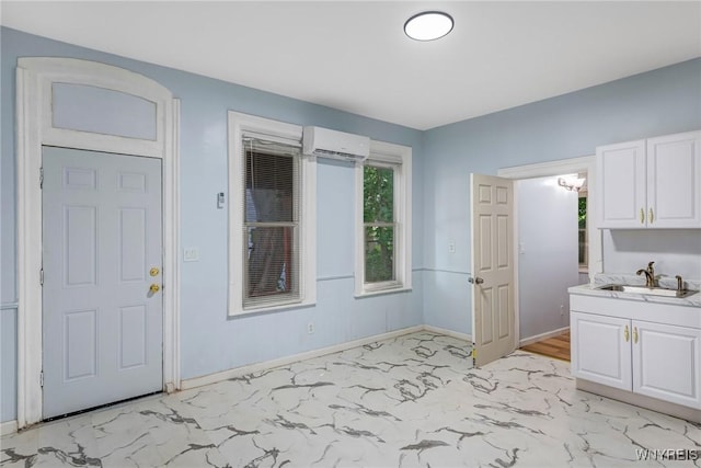 152 Mulberry St, Buffalo, NY 14204 - kitchen with a wall unit AC, light marble finish flooring, white cabinets, and light countertops