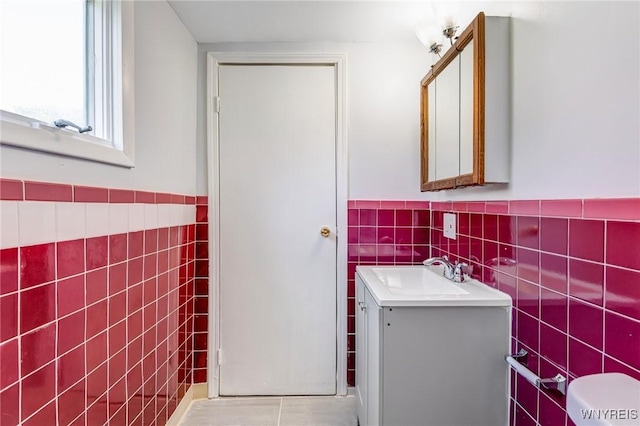 152 Mulberry St, Buffalo, NY 14204 - half bath featuring tile walls, vanity, tile patterned floors, and wainscoting