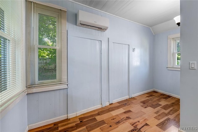 152 Mulberry St, Buffalo, NY 14204 - empty room with a wall unit AC, wood finished floors, and vaulted ceiling