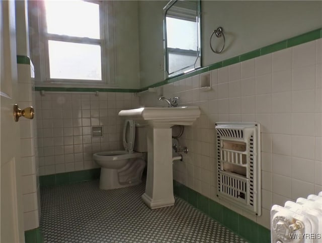 315 Laurens St, Olean-City, NY 14760 - bathroom with tile walls, radiator, tile patterned floors, healthy amount of natural light, and wainscoting