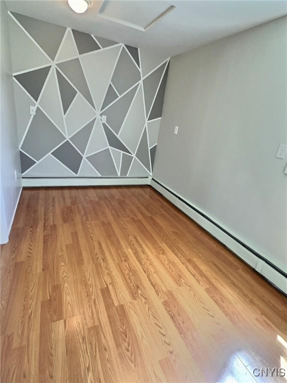4177 Austin Rd, Venice, NY 13118 - empty room with a baseboard radiator, wood finished floors, and attic access
