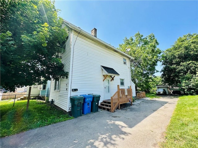 26 Kohlman St, Rochester, NY 14621 - view of property exterior featuring a chimney and driveway