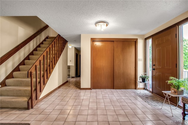 83 Randwood Dr, Amherst, NY 14068 - entrance foyer featuring stairs, light tile patterned flooring, and a textured ceiling