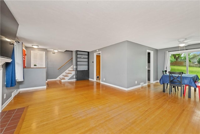 917 Whalen Rd, Penfield, NY 14526 - unfurnished living room with light wood-style floors, stairs, and ceiling fan