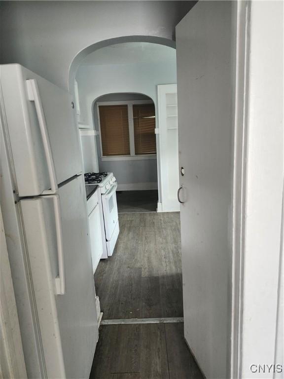 609 W Colvin St, Syracuse, NY 13205 - kitchen featuring white appliances, dark wood finished floors, arched walkways, and white cabinets