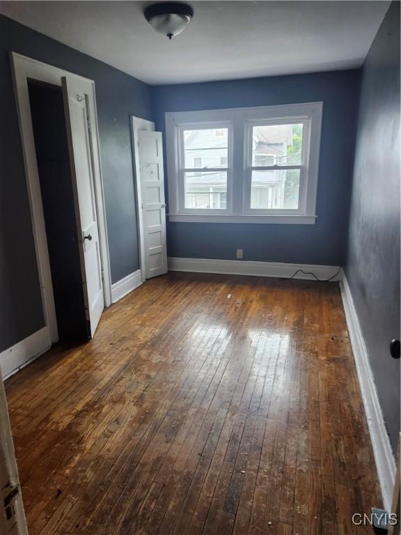 609 W Colvin St, Syracuse, NY 13205 - unfurnished bedroom with hardwood / wood-style flooring and baseboards