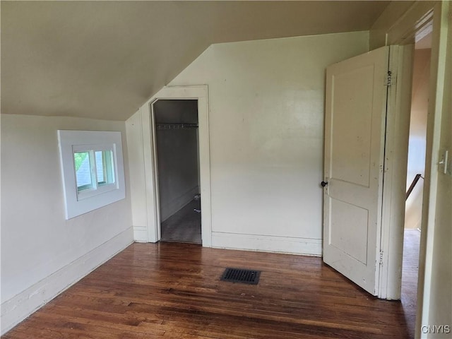 609 W Colvin St, Syracuse, NY 13205 - unfurnished bedroom with lofted ceiling, wood finished floors, a closet, and a walk in closet