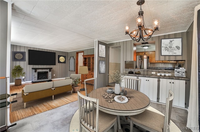 218 Hamilton Dr, Amherst, NY 14226 - dining space with a chandelier, ornamental molding, and a fireplace with raised hearth