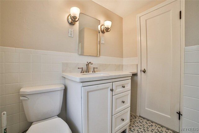 218 Hamilton Dr, Amherst, NY 14226 - bathroom with vanity, a wainscoted wall, and tile walls
