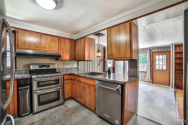 218 Hamilton Dr, Amherst, NY 14226 - kitchen with stainless steel appliances, under cabinet range hood, brown cabinets, dark countertops, and crown molding