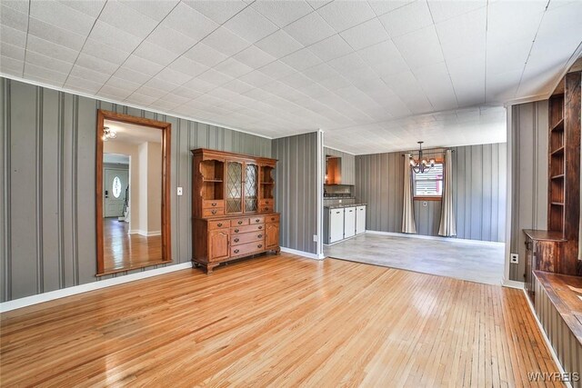 218 Hamilton Dr, Amherst, NY 14226 - unfurnished living room with light wood-style flooring and a chandelier