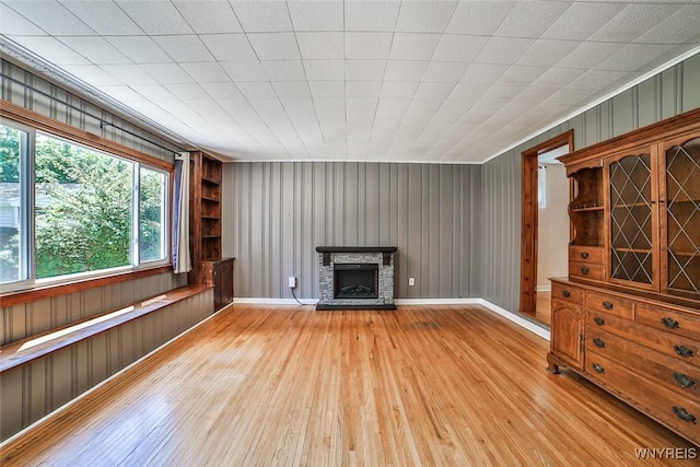 218 Hamilton Dr, Amherst, NY 14226 - unfurnished living room featuring light wood-type flooring, a fireplace, built in features, and wooden walls
