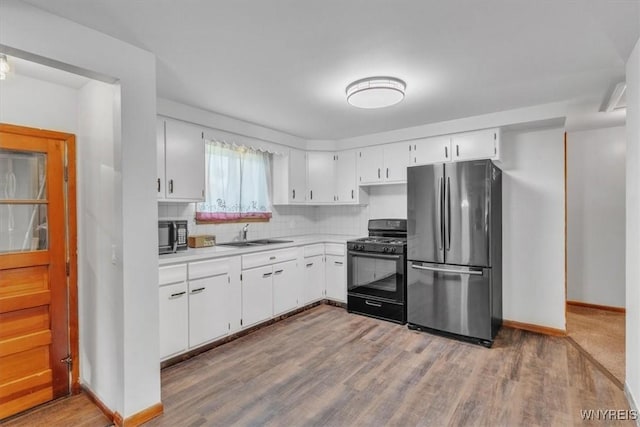 190 Gary Ln, Cheektowaga, NY 14227 - kitchen with black appliances, wood finished floors, decorative backsplash, and light countertops