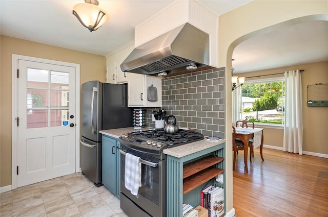 15 Baycrest Dr, Irondequoit, NY 14622 - kitchen featuring stainless steel appliances, island range hood, light countertops, backsplash, and arched walkways