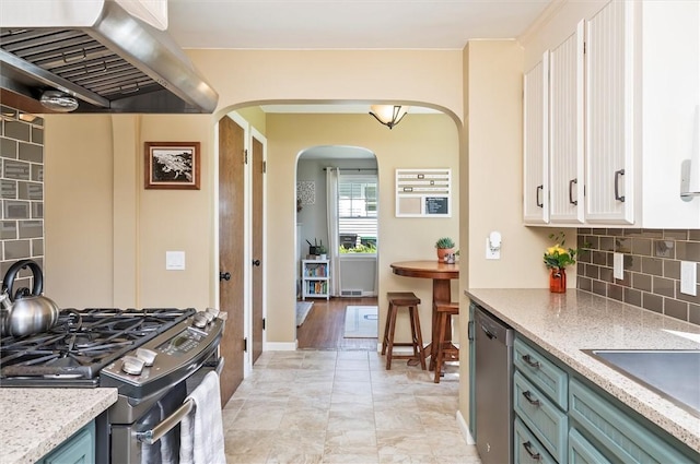 15 Baycrest Dr, Irondequoit, NY 14622 - kitchen with range hood, stainless steel appliances, arched walkways, white cabinetry, and decorative backsplash