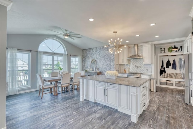 28 Blaydon Loop, Henrietta, NY 14586 - kitchen featuring wall chimney range hood, white cabinetry, appliances with stainless steel finishes, dark wood-style flooring, and vaulted ceiling