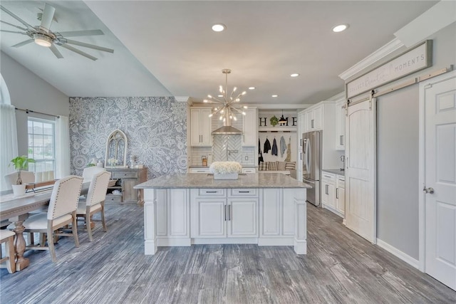 28 Blaydon Loop, Henrietta, NY 14586 - kitchen with wood finished floors, a chandelier, a barn door, freestanding refrigerator, and a center island