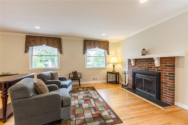 45 Barnfield Rd, Henrietta, NY 14534 - living area with wood finished floors, plenty of natural light, a brick fireplace, ornamental molding, and recessed lighting