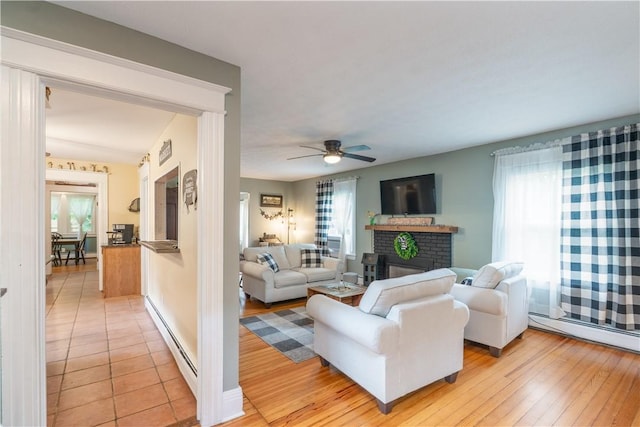 70 E Main St, Avon, NY 14414 - living area featuring a baseboard radiator, a fireplace, healthy amount of natural light, and ceiling fan