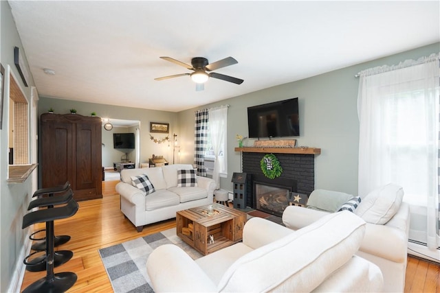 70 E Main St, Avon, NY 14414 - living area with a ceiling fan, a brick fireplace, and light wood-style floors